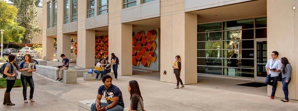 UCR students chat and study outside of a classroom building